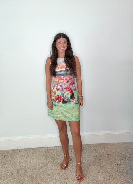 Girl in a watercolor football printed dress standing in front of a white wall 